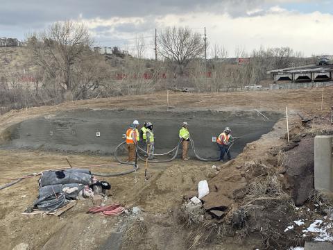 Workers construct a shotcrete shoring wall.