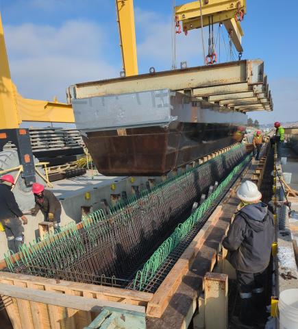 Workers fabricating the girders for the westbound bridge above fountain creek.