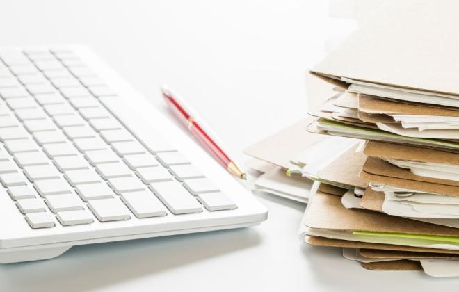 computer keyboard and stack of files