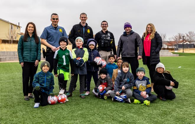 police officers pose with a youth soccer team