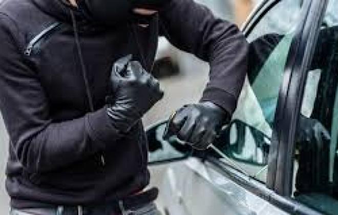 Man breaking into car.