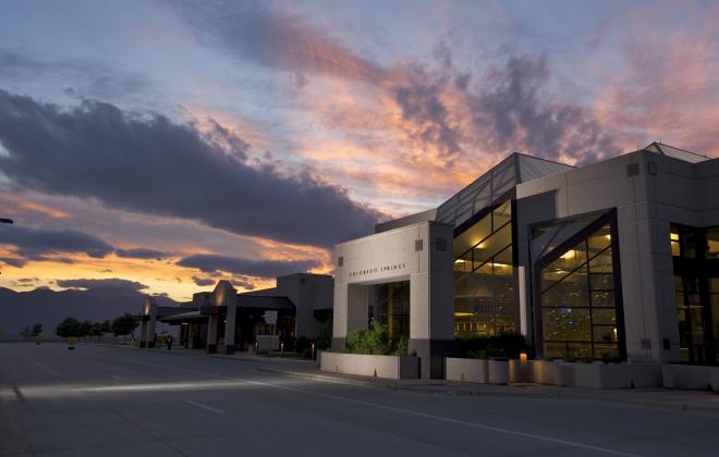 Colorado Springs Airport at dusk with beautiful purple and orange sunset and Pikes Peak in the background